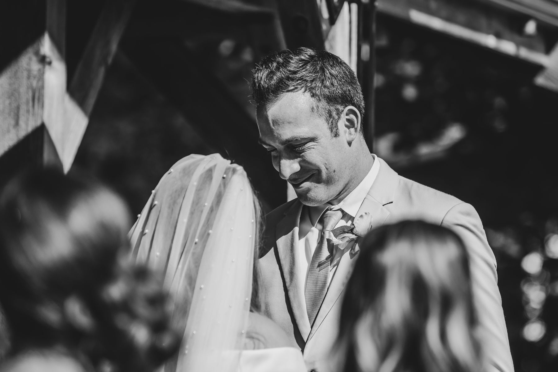 black and white photo of happy groom during ceremony