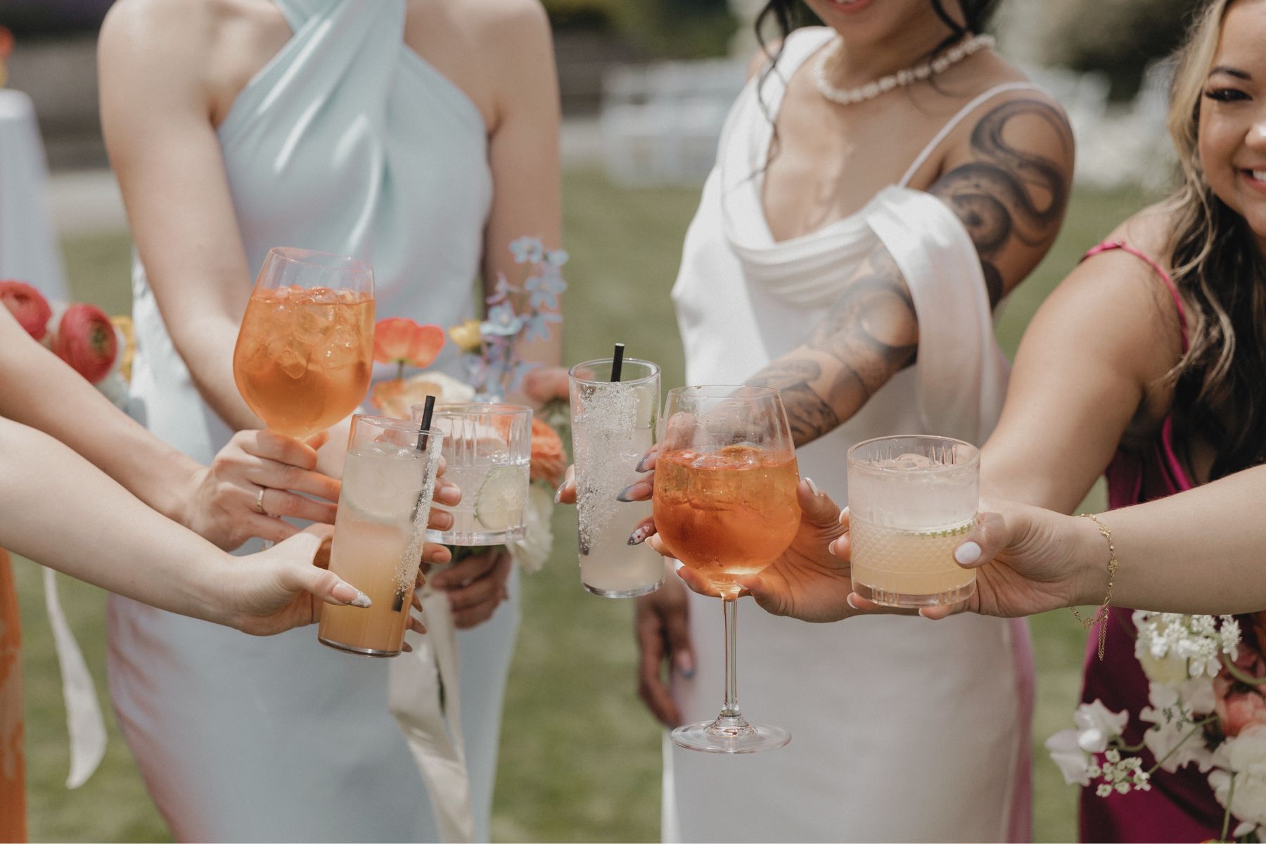 Bride and bridesmaids toasting with signature cocktail and aperol spritz