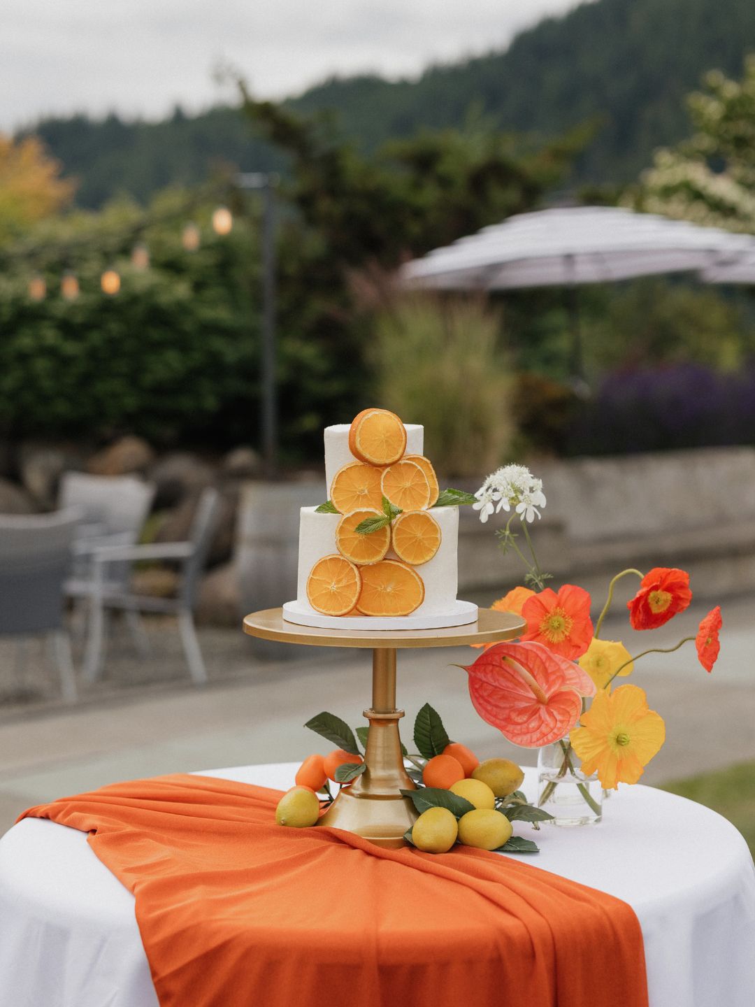 Citrus wedding cake set against the lush pine green foothills of the PNW