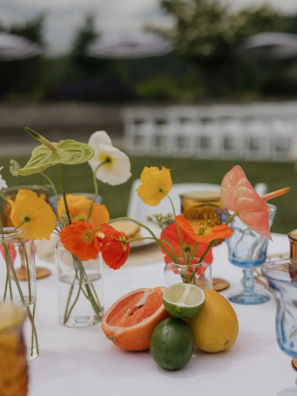Vibrant citrus table styling with sliced grapefruit, oranges, limes, yellow flowers, and cocktail drinks in glassware