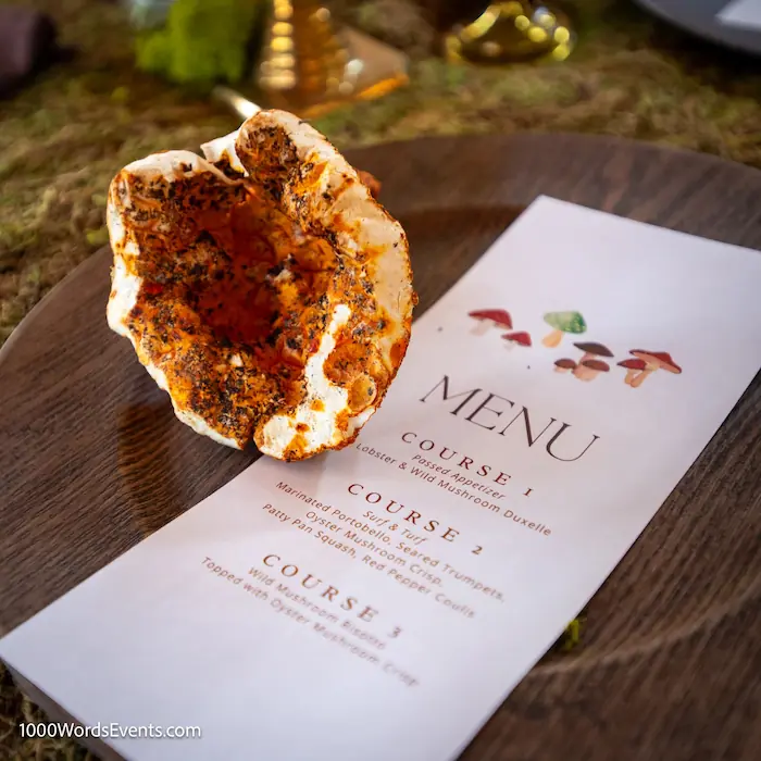 Closeup of mushroom inspired three course farm to table dinner menu laid on a wood charger with a giant lobster mushroom