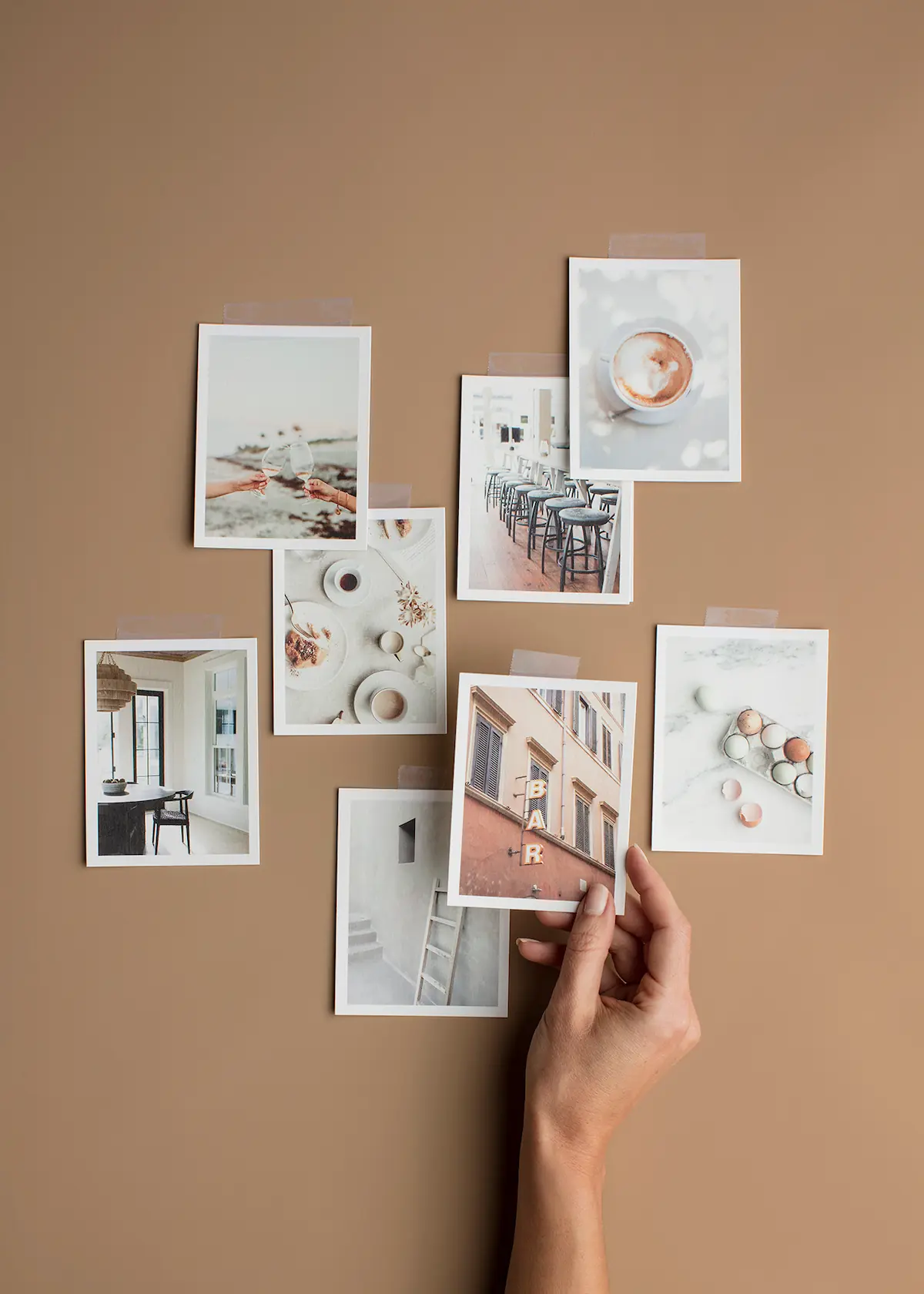 Hands arranging mood board photo prints and design inspiration cards on a neutral backdrop