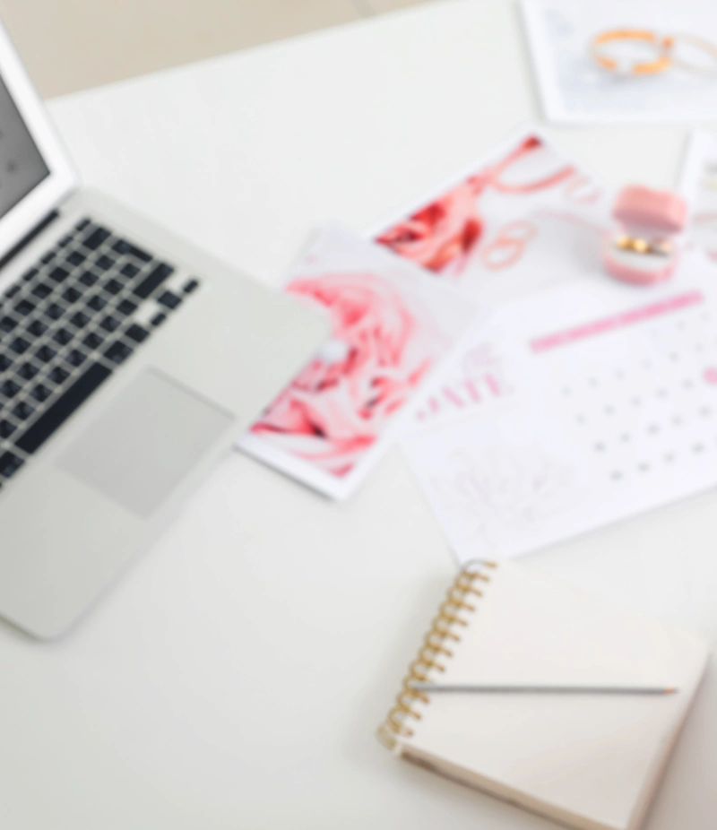 Event planning workspace with an open laptop, spiral notebook, mood board color swatches, and design samples
