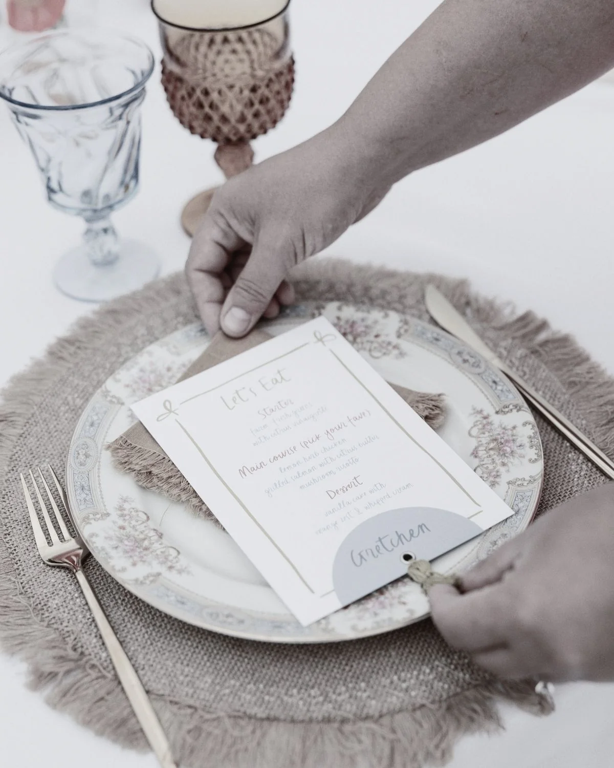 Close up of wedding planners hands adjusting the napkin and menu on guests table setting