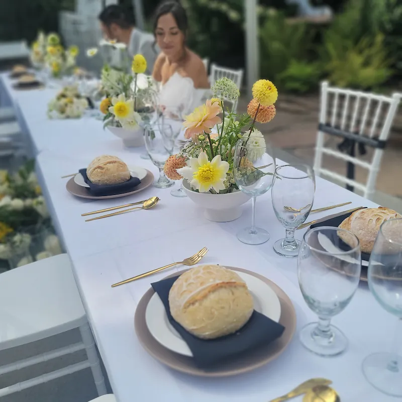 Minimalist place setting featuring a stone plate, black napkin, and an artisan sourdough boule