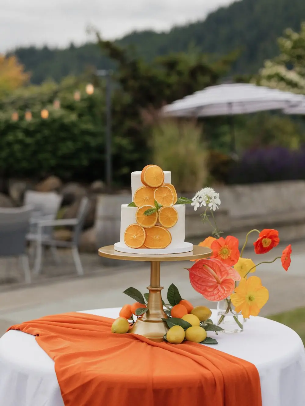 Citrus wedding cake set against the lush pine green foothills of the PNW